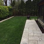 Hedging curbing patio accentuated by fake grass