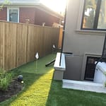 narrow synthetic golf green at side yard