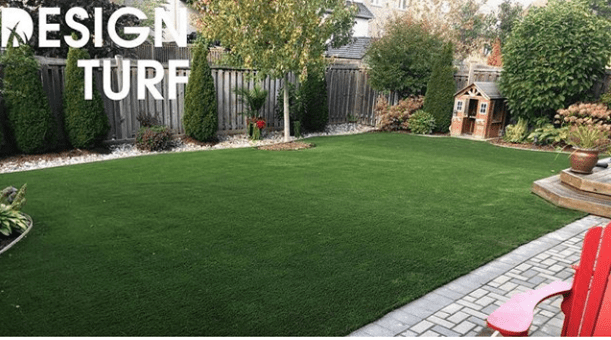 clean backyard river rock patio with deck plantings